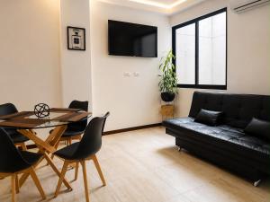 a living room with a black couch and a table at Departamento completo en zona Turística de Santa Cruz in Santa Cruz de la Sierra +7 photos