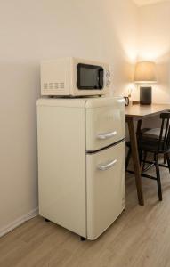 a microwave on top of a refrigerator with a table at 303 Stayonyou Gocheok Dome Hongdae Subway 3Min in Gwangmyeong