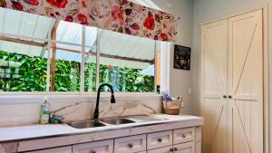 a kitchen with a sink and a window at Hermosa casa con aire acondicionado rodeada de aves y naturaleza incluye desayuno in Puyo +22 photos