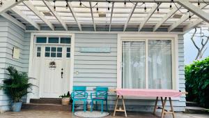 a house with two blue stools on the front porch at Hermosa casa con aire acondicionado rodeada de aves y naturaleza incluye desayuno in Puyo