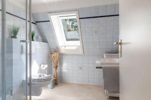 a bathroom with a toilet and a window at Villa-Magnolia-H in Hohwacht +53 photos