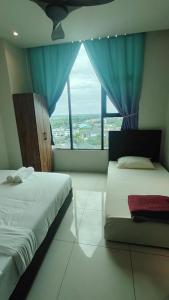 a bedroom with two beds and a large window at CeeJay Suites in Penampang