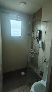 a bathroom with a shower with a toilet and a window at CeeJay Suites in Penampang +12 photos