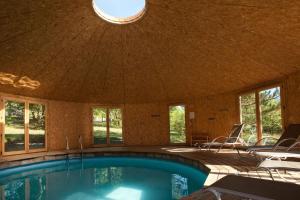 a large swimming pool in a house with windows at Gite 4 etoiles en pleine nature 8 pers. in Entrepierres