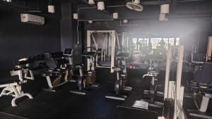 a gym with cardio equipment in a black room at CeeJay Suites in Penampang