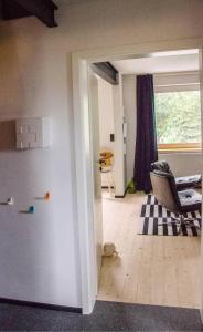 an open door to a living room with a chair at AHOI-MARIE in Blekendorf +22 photos