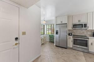 a kitchen with white cabinets and stainless steel appliances at Spacious 2BR 2BA apartment close to the beach in Jupiter