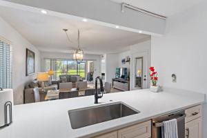 a kitchen with a sink and a living room at Spacious 2BR 2BA apartment close to the beach in Jupiter