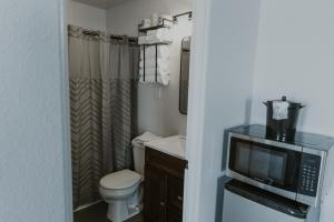 a small bathroom with a toilet and a television at The Last Resort in Sault Ste. Marie +37 photos