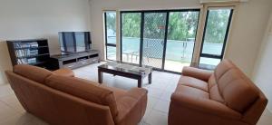 a living room with two couches and a television at Penguins by the Beach in Cowes