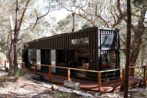 a black tiny house on a deck in the woods at SHAK Halls Gap - Off Grid Tiny Home in Halls Gap