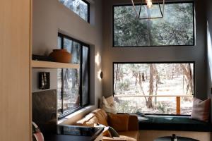 a living room with two large windows and a couch at SHAK Halls Gap - Off Grid Tiny Home in Halls Gap +12 photos