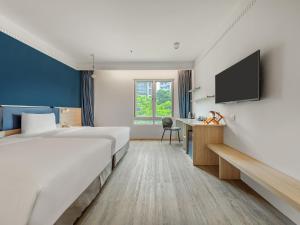 a hotel room with a bed and a flat screen tv at CHECK inn Select Taipei Nangang in Taipei