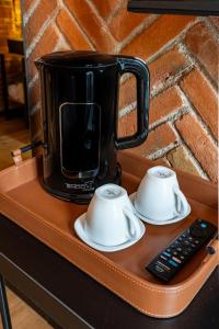 a coffee pot on a table with a remote control at Hotel Terracota mx in Mexico City