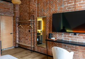 a brick wall with a flat screen tv on a wall at Hotel Terracota mx in Mexico City
