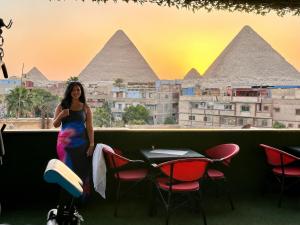 a woman standing in front of a view of the pyramids at Master kings of the pyramids and Sphinx in Cairo