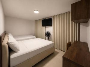 a bedroom with a bed and a television in it at Hotel Balcones del Estadio in Medellín