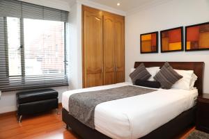 a bedroom with a large bed and a window at Hotel Suites 108 in Bogotá