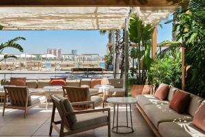 a patio with couches and tables and a pool at W Barcelona in Barcelona