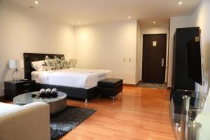 a hotel room with a bed and a couch at Hotel Suites 108 in Bogotá