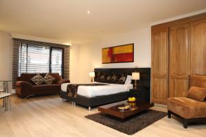 a bedroom with a bed and a couch and a table at Hotel Suites 108 in Bogotá +58 photos