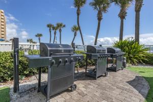 two bbqurgers and a grill with palm trees at Hilton Vacation Club Daytona Seabreeze Daytona Beach in Daytona Beach