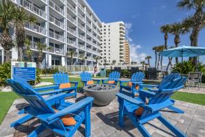 a group of blue chairs and an umbrella at Hilton Vacation Club Daytona Seabreeze Daytona Beach in Daytona Beach