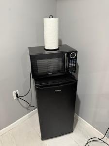 a microwave sitting on top of a black refrigerator at 50 Private Lounge in Irvington