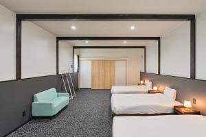 a hotel room with three beds and a blue chair at Aoyagi Stay in Shiomichō +37 photos
