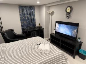 a bedroom with a bed and a flat screen tv at 50 Private Lounge in Irvington