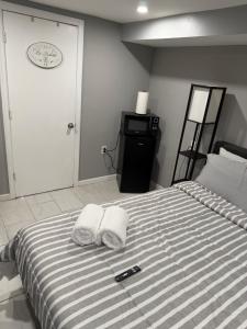 a bed with two towels and a remote control on it at 50 Private Lounge in Irvington