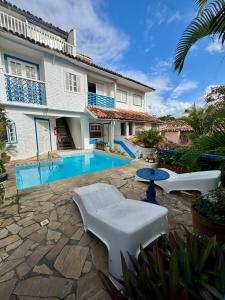 a villa with a swimming pool and a house at Luah Buziana in Búzios