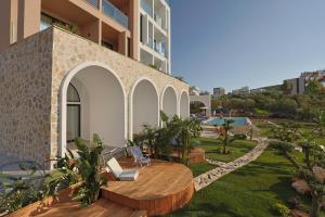 a building with a table and chairs in a yard at Hotel Camelot By Artur in Ksamil
