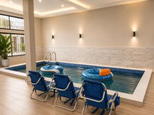 a pool with chairs and inflatables in a hotel room at The Blue Resort in Yaoundé