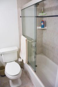 a bathroom with a toilet and a glass shower at Jupiter Bay Beach Condo in Jupiter