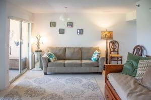 a living room with a couch and a window at Jupiter Bay Beach Condo in Jupiter