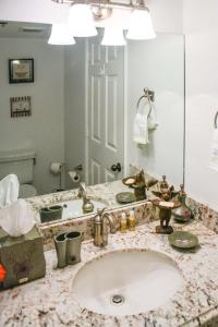 a bathroom with a sink and a large mirror at Jupiter Bay Beach Condo in Jupiter