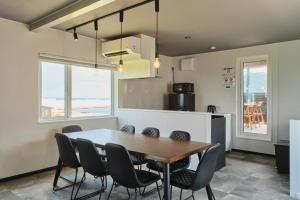 a kitchen and dining room with a table and chairs at Aoyagi Stay in Shiomichō