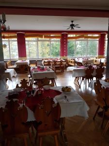 a dining room with tables and chairs and windows at KORONA Sanatorium Uzdrowiskowe in Muszyna