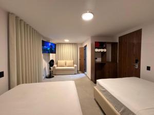 a hotel room with two beds and a couch at Hotel Balcones del Estadio in Medellín
