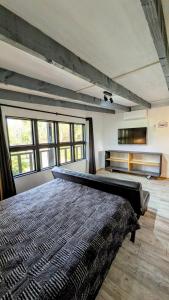 a bedroom with a large bed in a room with windows at Molco Cabins Palafito in Pucón