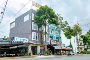 a building on the side of a street with a tree at Khách sạn Caravelle Cần Thơ 2 in Can Tho