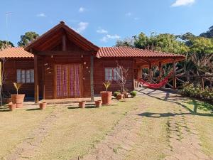 a house with a playground in front of it at Recanto Sol Maior - Casa Lírio in Sapucaí-Mirim +15 photos