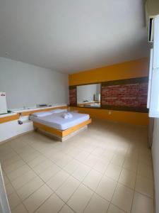 a large room with a bed and a brick wall at Eros Motel Hotel in Caicó