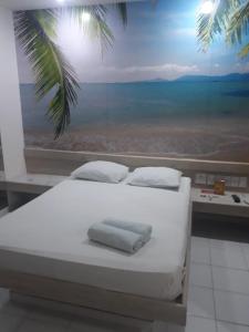a bed in a room with a view of the ocean at Eros Motel Hotel in Caicó