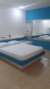 a large bed in a room with blue walls at Eros Motel Hotel in Caicó