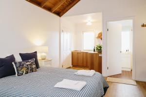 a bedroom with a bed with a blue and white checked blanket at Suma Park Estate in Point Lonsdale