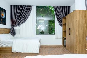 a bedroom with a bed and a window at Khách sạn Caravelle Cần Thơ 2 in Can Tho