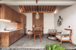 a kitchen and living room with a table and chairs at Teratai Villa Canggu by Ini Vie Hospitality in Canggu