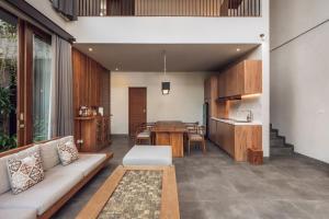 a living room with a couch and a table at Teratai Villa Canggu by Ini Vie Hospitality in Canggu